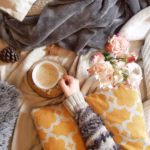 overhead-photo-hand-holsdimg-coffee-cup-warm-cozy-lifestyle_1048944-17668369